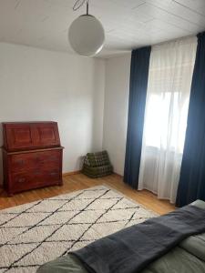 a bedroom with a bed and a dresser and a window at Schönes Haus in der Wetterau in Utphe