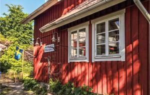een rood huis met twee ramen aan de zijkant bij Awesome Home In Tors With Kitchen in Brommösund