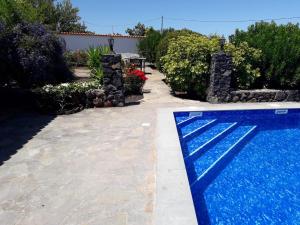 a swimming pool next to a yard with a house at 2 bedrooms villa with sea view private pool and furnished terrace at Puntagorda in Puntagorda