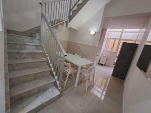 a dining room with a table and stairs in a house at No18 Cospicua in Cospicua