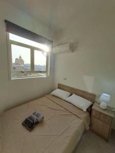 a bedroom with a large bed with a window at No18 Cospicua in Cospicua