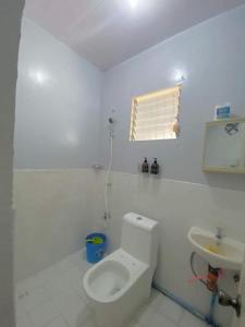 Baño blanco con aseo y lavamanos en AB Yam Staycation Gensan near Venue88, en General Santos