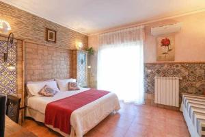 sypialnia z łóżkiem z czerwonym kocem i oknem w obiekcie Casa della Giara w mieście Giarre
