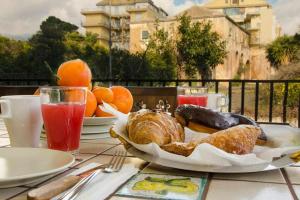 a table with a plate of bread and other foods on it at Casa della Giara in Giarre