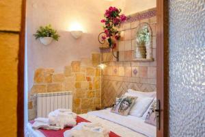 mały pokój z łóżkiem i ścianą z kwiatami w obiekcie Casa della Giara w mieście Giarre