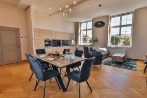 uma sala de jantar e sala de estar com mesa e cadeiras em Domaine Grand Piquecaillou - Appartement Pessac Leognan 