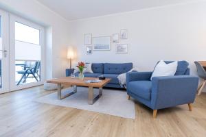 ein Wohnzimmer mit einem blauen Sofa und einem Tisch in der Unterkunft Ferienwohnung Jonte in Sassnitz