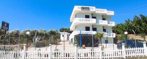 a white building with a fence in front of it at Creta Star Apartments in Agia Galini