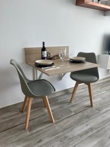 a table with two chairs and a bottle of wine at Hideaway Tenerife Holiday Apartment Las Américas in Playa Fañabe