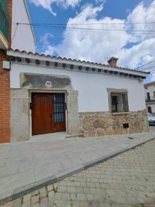 艾蒂恩夫洛的住宿－El rincón de Gondi，街道上带有木门的白色建筑