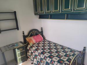 sypialnia z łóżkiem z kołdrą w obiekcie Jardine Al Andalous w mieście Tanger