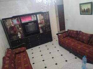 a living room with a couch and a tv at Jardine Al Andalous in Tangier