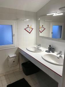łazienka z 2 umywalkami, lustrem i toaletą w obiekcie Maison 3 chambres - Chez Florence w mieście Yzeure