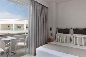 コス・タウンにあるAnastasia Hotel & Apartmentsのベッドルーム1室(ベッド1台付)、バルコニー(テーブル、椅子付)