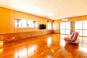 Una sala de estar con una silla y un televisor. en えびす家, en Ishigaki Island