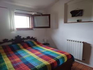 - une chambre avec un lit et une couverture colorée dans l'établissement Casa di campagna in Podere con piscina, à Torrita di Siena