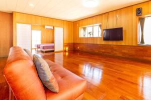 a living room with a couch and a flat screen tv at えびす家 in Ishigaki Island