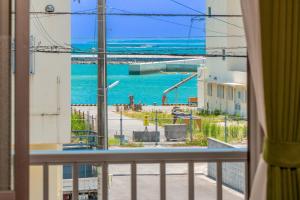a room with a view of the ocean from a balcony at えびす家 in Ishigaki Island