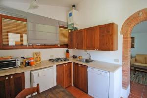 - une cuisine avec des placards en bois et un comptoir dans l'établissement Casa di campagna in Podere con piscina, à Torrita di Siena