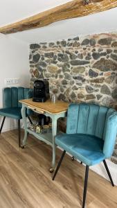 una mesa y sillas en una habitación con una pared de piedra en Can Jan Vives en Vidreres