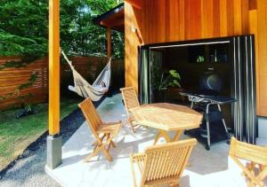 d'une terrasse avec une table, des chaises et un hamac. dans l'établissement GREEN SEED Karuizawa, à Karuizawa