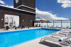 a swimming pool with chairs and a clock on a building at Renaissance Reno Downtown Hotel & Spa in Reno