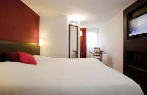 Un pat sau paturi într-o cameră la ibis Styles Belfort Centre