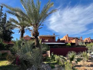 a palm tree in front of a house at La Villa 2A in Marrakesh