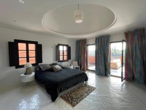 a bedroom with a bed in a room with windows at La Villa 2A in Marrakesh