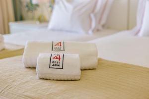 a group of four towels sitting on top of a bed at Rent4Rest Estoril Beachfront Apartments in Estoril