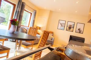 a dining room with a table and chairs at Druim An Lochain Cottage in Kinrara