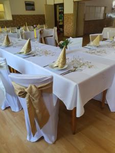 uma fila de mesas com panos de mesa brancos em Ubytování Hilšer em Potštát
