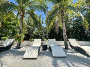 um grupo de cadeiras e palmeiras num pátio em Tantawan sea view residence 山海居 em Salad Beach