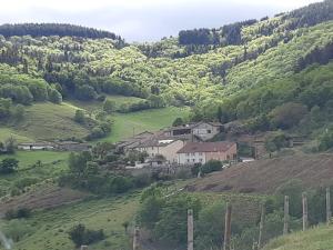 a house on a hill in a green valley at Les Chambres d'Hôtes d'Alice Dior in Blacé