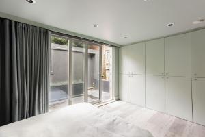 a bedroom with white cabinets and a large window at 189A Caledonian Road, London, N1 0SL in London