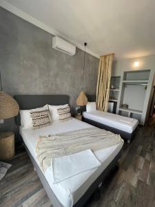 a bedroom with a large white bed and a mirror at Xenios Hotel in Pefkochori