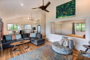 a living room with a couch and a table at Heliconia 10 Newly Renovated Centrally Located House Hamilton Island in Hamilton Island