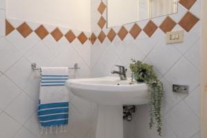 a white bathroom with a sink and a mirror at Villa Giada in Stintino