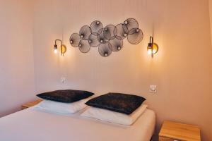 ein Schlafzimmer mit einem Bett mit zwei Kissen darauf in der Unterkunft Domaine Grand Piquecaillou - L'appartement Saint Macaire 