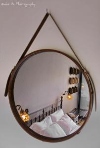 a mirror reflecting a bed with white pillows at Niriides Luxury Apartments in Syvota