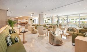 a lobby with couches and tables and chairs at Hipotels Mediterraneo Hotel - Adults Only in Sa Coma