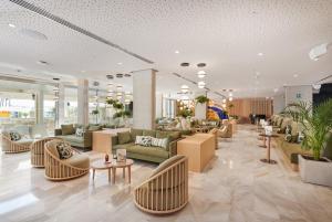 a lobby with couches and chairs and tables at Hipotels Mediterraneo Hotel - Adults Only in Sa Coma
