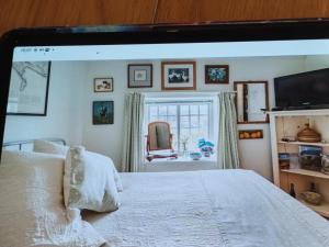 1 dormitorio con 1 cama blanca y TV en Number Five, en Abbotsbury