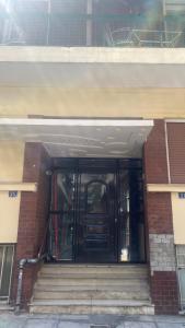 a front door of a building with stairs in front at Modern Cozy Apartment in Downtown Athens in Athens