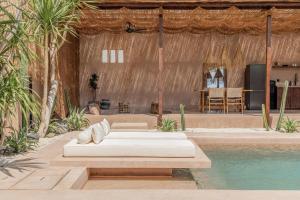 a bed sitting next to a pool next to a house at Abu X Abu in Canggu