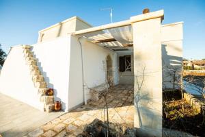 una casa bianca con una scala di fronte di Lamia del carrubo a San Vito dei Normanni