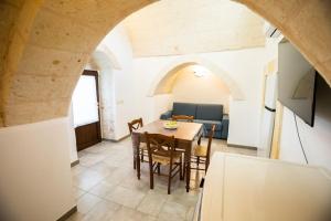 una sala da pranzo con un tavolo e un divano di Lamia del carrubo a San Vito dei Normanni Altre 14 foto