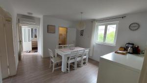 a kitchen and dining room with a white table and chairs at Sailing Forever Bungalow in Kaštela