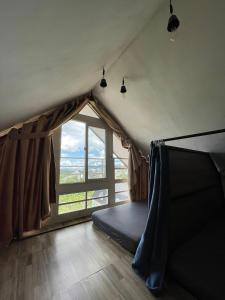 Zimmer mit einem Zelt und einem großen Fenster in der Unterkunft Tigon Dalat Hostel in Da Lat