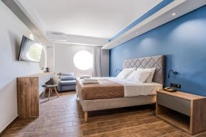 a bedroom with a bed and a blue wall at Island City Boutique Hotel in Rhodes Town